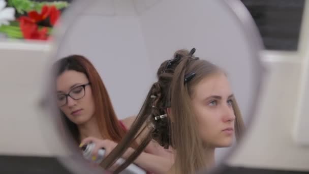 Профессиональный парикмахер делает прическу для молодой красивой женщины - делает кудри — стоковое видео
