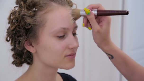 Cinco disparos. Maquillaje artista aplicando base tonal líquida en la cara de la chica adolescente — Vídeo de stock