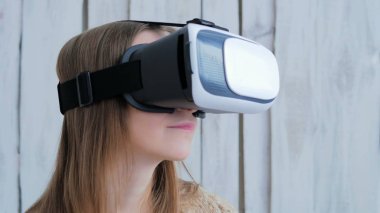 Sanal gerçeklik gözlüğü kullanan genç bir kadın.