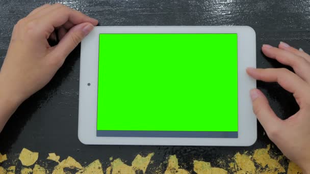 Woman looking at tablet computer with green screen — Stock Video