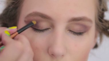 Profesyonel makyöz göz farı kullanıyor.