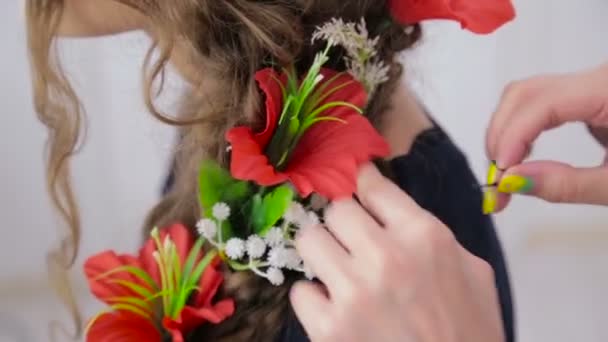 Hairstylist, hairdresser finishing creative hairstyle with flowers for teen girl — Stock Video