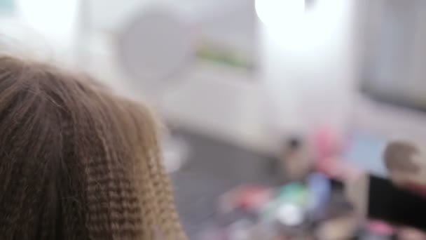 2 výstřely. Profesionální kadeřník dělá účes pro Mladá krásná žena s dlouhými vlasy — Stock video