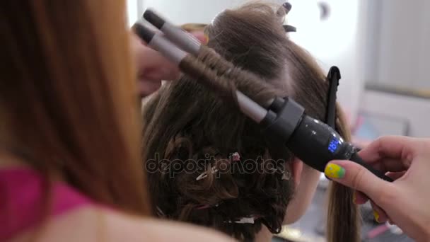 Professional hairdresser doing hairstyle for pretty teen girl — Stock Video