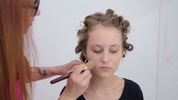 Visagist toepassing van vloeibare tonale Stichting op het gezicht van tiener meisje — Stockvideo