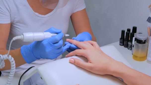 De meester maakt gebruik van een elektrische machine te verwijderen van de nagellak — Stockvideo