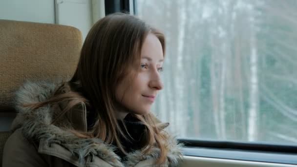 Zamyšlená žena uvolňující a při pohledu z okna vlaku — Stock video
