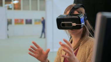 Sanal gerçeklik gözlüğü kullanan genç bir kadın.