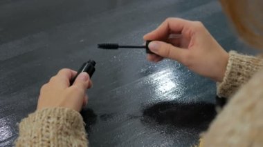 Açma ve maskara koyarak güzel genç kadın