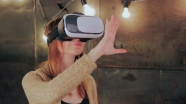 Sanal gerçeklik gözlüğü kullanan genç bir kadın.
