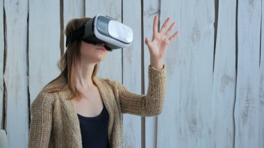 Sanal gerçeklik gözlüğü kullanan genç bir kadın.