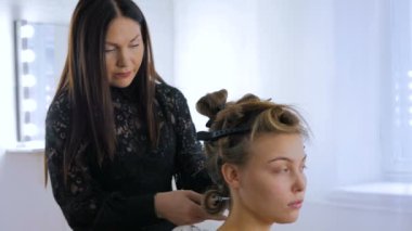 Profesyonel kuaför saç modeli için genç kadın güzel yapıyor