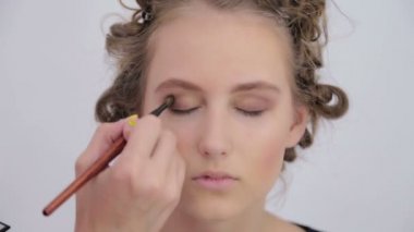 Profesyonel makyöz göz farı kullanıyor.