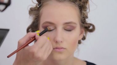 Profesyonel makyöz göz farı kullanıyor.