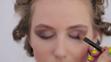 Profesyonel makyöz göz farı kullanıyor.