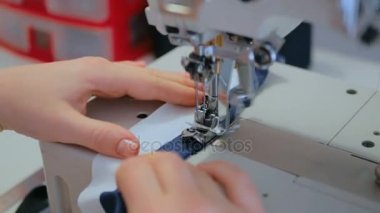 Profesyonel terzi, moda tasarımcısı dikiş makinesiyle elbise dikiyor.