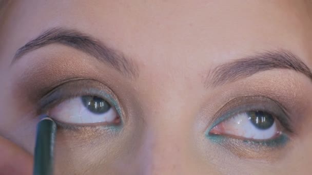 Maquillaje profesional artista aplicando delineador de ojos alrededor de todo el ojo del modelo — Vídeos de Stock