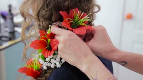 Hairstylist, hairdresser finishing creative hairstyle with flowers for teen girl — Stock Video