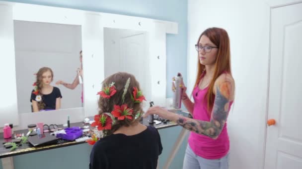 Hairstylist, hairdresser finishing creative hairstyle with flowers for teen girl — Stock Video