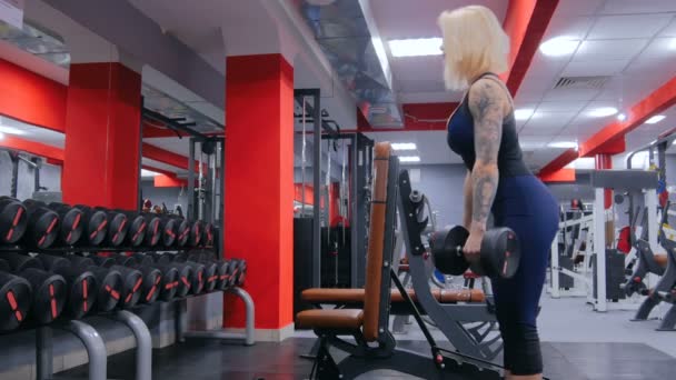 Atlético jovem mulher levantando halteres no ginásio — Vídeo de Stock