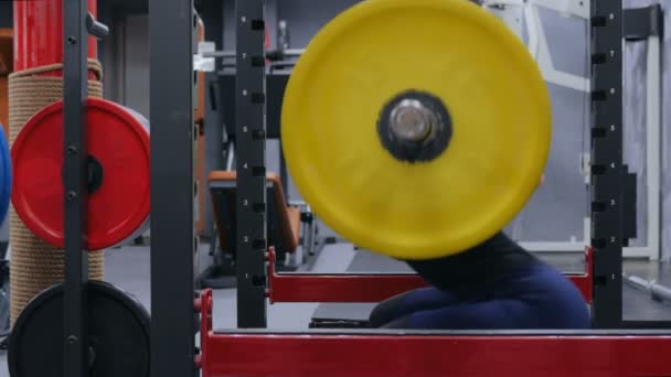 Spor salonunda halterle egzersiz yapan atletik genç bir kadın. — Stok video