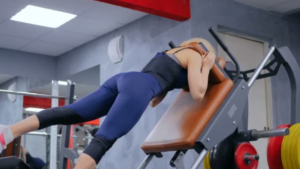 Atletische jonge vrouw die traint op fitnesstoestellen — Stockvideo