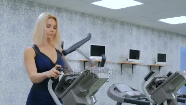 Атлетичная молодая женщина работает на шаговую машину в тренажерном зале — стоковое видео