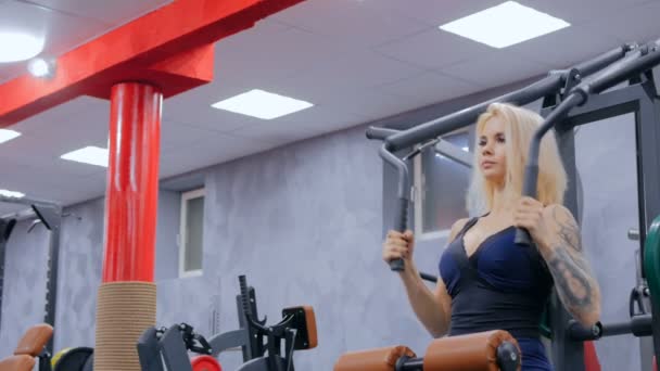 Sportliche junge Frau trainiert an Fitnessgeräten — Stockvideo