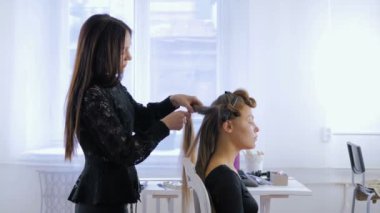 Profesyonel kuaför saç modeli için genç kadın güzel yapıyor