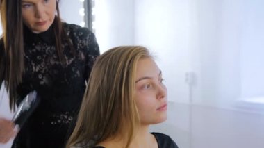 Profesyonel kuaför saç modeli için genç kadın güzel yapıyor