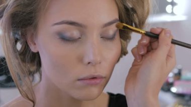 Profesyonel makyöz göz farı kullanıyor.