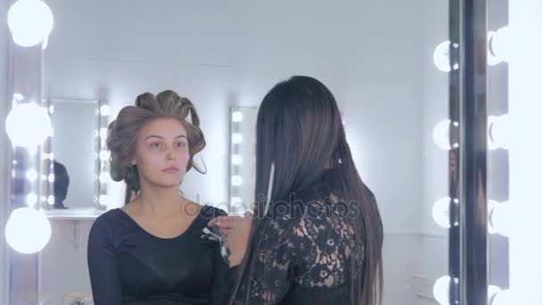 Μακιγιάζ καλλιτέχνης εφαρμόζοντας το υγρό make up τονικό στο γυναικείο πρόσωπο — Αρχείο Βίντεο