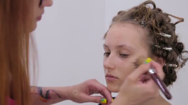 Μακιγιάζ καλλιτέχνης εφαρμόζοντας το υγρό make up τονικό εκ πρώτης όψεως έφηβος κορίτσι — Αρχείο Βίντεο
