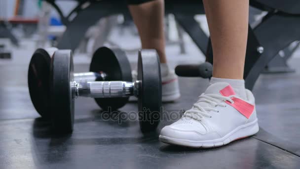 Gros plan de la jeune femme sportive soulevant des haltères à la salle de gym — Video