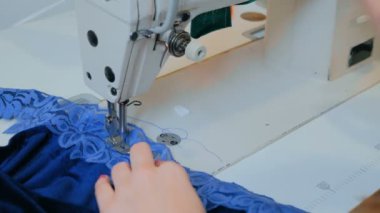 Profesyonel terzi, moda tasarımcısı dikiş makinesiyle elbise dikiyor.