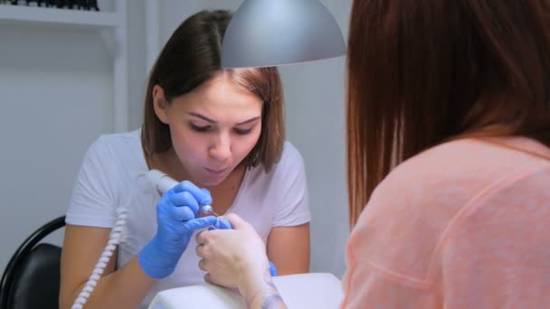 Manicura de hardware em um salão. Manicure está aplicando broca elétrica de arquivo de unhas — Vídeo de Stock