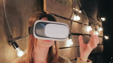Sanal gerçeklik gözlüğü kullanan genç bir kadın.