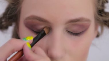 Profesyonel makyöz göz farı kullanıyor.