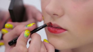İstemci dudaklarından ruj uygulama profesyonel makyaj sanatçısı