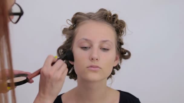 Artista de maquillaje profesional aplicando polvo a la cara de las mujeres — Vídeo de stock