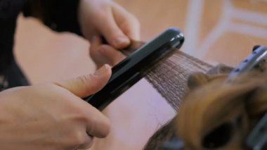 Kuaför Salonu istemcisinin uzun saç düzleştirici kullanarak Kuaför