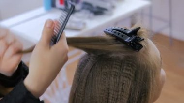 Profesyonel kuaför saç modeli için genç kadın güzel yapıyor