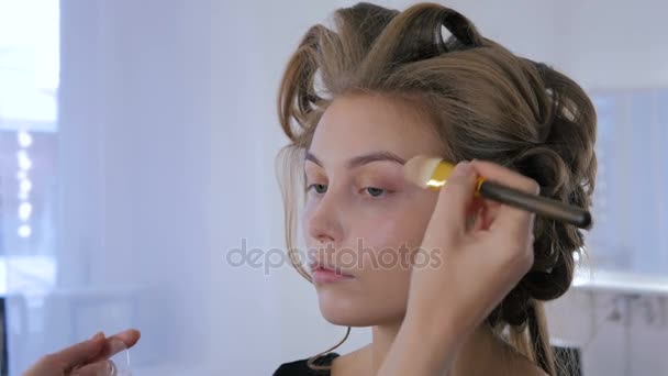 Μακιγιάζ καλλιτέχνης εφαρμόζοντας το υγρό make up τονικό στο γυναικείο πρόσωπο — Αρχείο Βίντεο