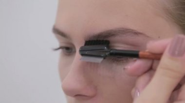 Kaşları istemcisinin penye profesyonel makyaj sanatçısı