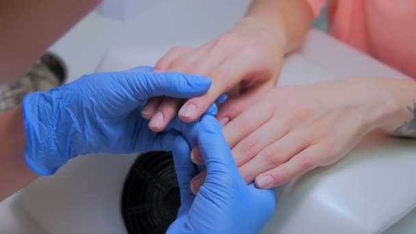 La manicura toma de la mano del cliente en el salón de belleza — Vídeos de Stock