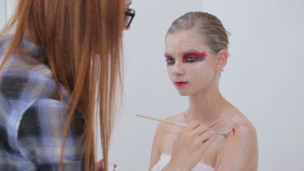 7 disparos. Artista de maquillaje profesional haciendo arte corporal en habitación blanca — Vídeo de stock