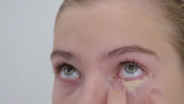 Профессиональный визажист наносит кремовую грунтовку тени для век на модель глаза — стоковое видео