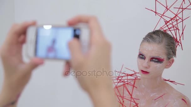 Visagistin fotografiert ihre Kundin mit kreativem, ungewöhnlichem Make-up — Stockvideo