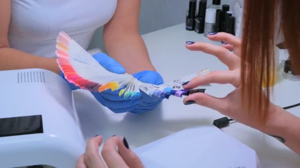 Seis disparos. Técnico de uñas muestra la paleta de colores de los servicios de uñas en el salón de belleza . — Vídeos de Stock