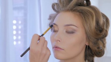 Profesyonel makyöz kadının yüzünde makyaj uygulamak